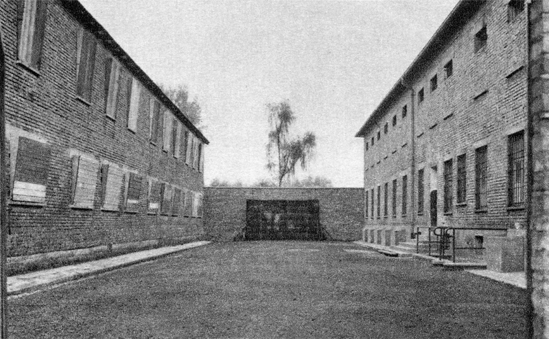 Auschwitz-I. La cour séparant le Block 10 - où se pratiquaient les expérimentations “médicales” sur des femmes détenues - et le Block 11, à droite, la prison du camp, avec le 1er étage de la “quarantaine”. Au fond, le mur des fusillés. Carte postale. Collection Mémoire Vive.