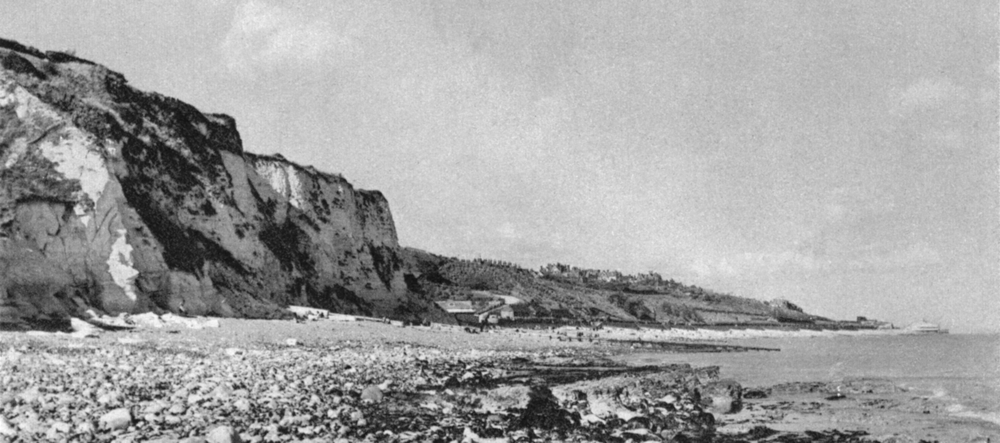 À marée basse sous les falaises d’Holywell au sud de la ville balnéaire d’Eastbourne, visible à l’arrière plan à droite. Carte postale non datée, collection Mémoire Vive.