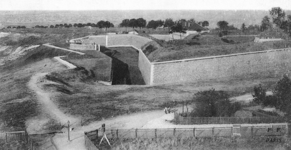 Le fort de Romainville, vue du côté nord. À l’intérieur de l’enceinte, on distingue le haut du bâtiment de caserne. Carte postale oblitérée en 1915. Collection Mémoire Vive.