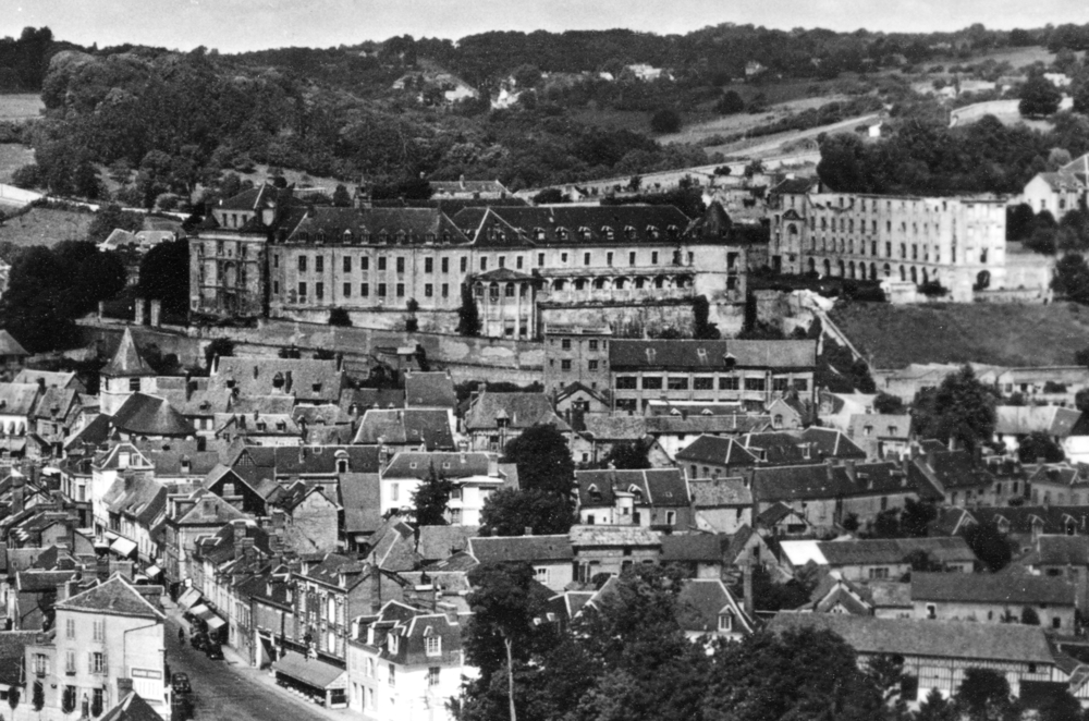 Le château de Gaillon, au-dessus du village. Les internés sont assignés au pavillon Colbert, le grand bâtiment isolé à droite (lequel a perdu sa toiture après la guerre) Carte postale des années 1950.  Collection Mémoire Vive.