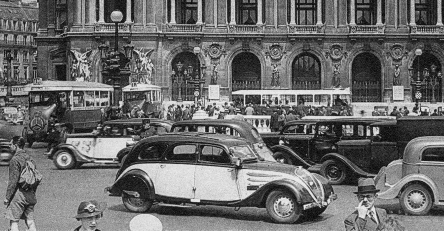 Un taxi parisien au milieu de la circulation, place de l’Opéra dans les années 1930. Carte Postale, collection Mémoire Vive.