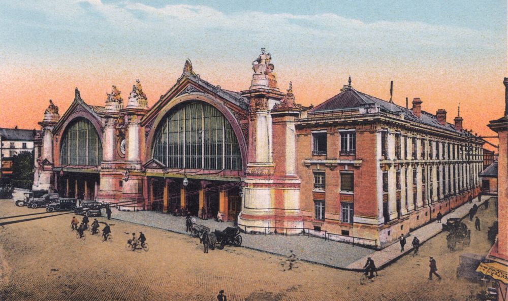 Tours, la gare de la ligne Paris-Orléans (P.O.) dans les années 1920. La porte de service par laquelle les Tourangelles ont été conduites vers un train se trouve au fond de la rue de Nantes, à droite. Carte postale colorisée, collection Mémoire Vive.